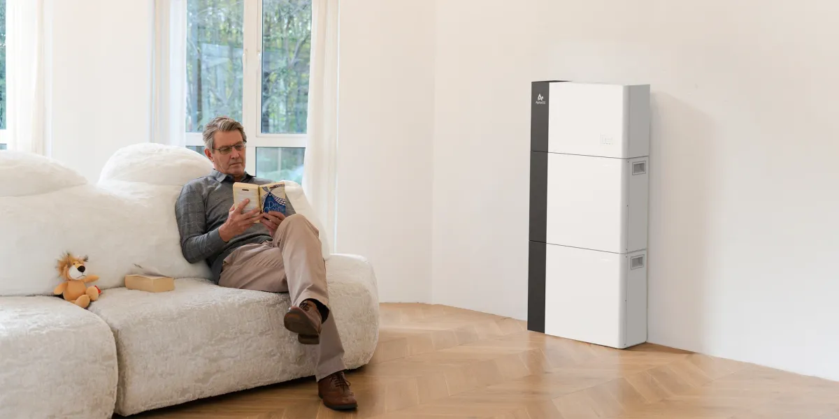 Man relaxing at home with home battery system in living room